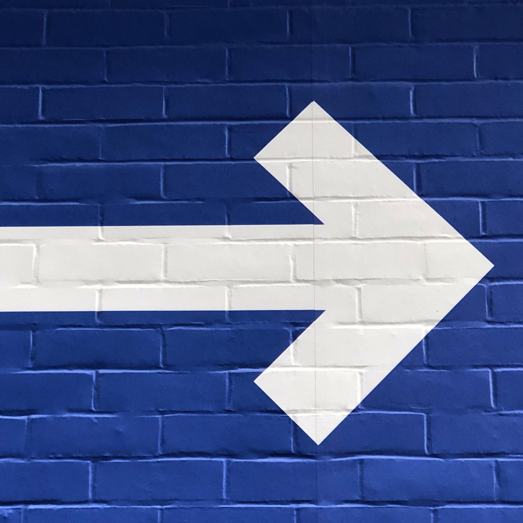 White arrow pointing right on blue background 